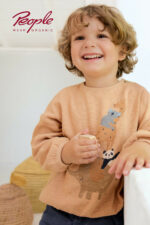 Kind trägt einen langärmeligen Pullover mit Tiermotiv in Honiggelb von People Wear Organic