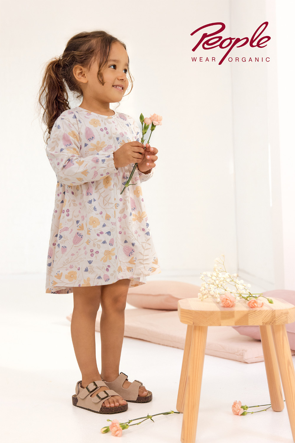 Mädchen trägt ein Kleid mit Blumenmuster in Puderrosa von People Wear Organic