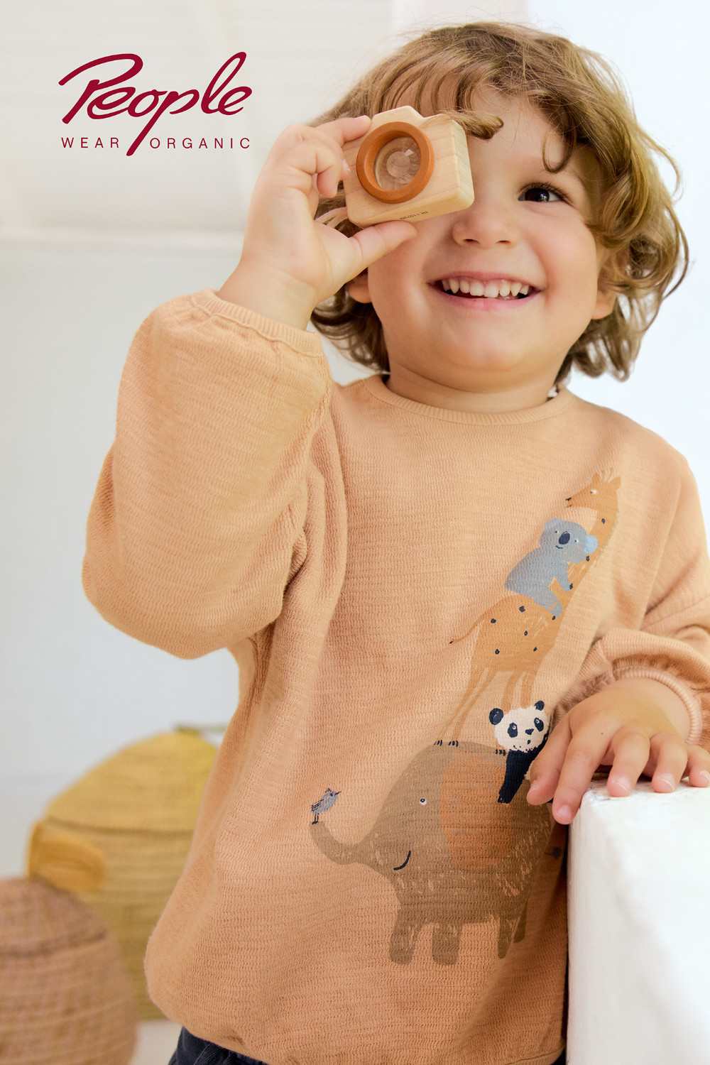 Kind trägt einen honiggelben Pullover mit Tiermotiv von People Wear Organic